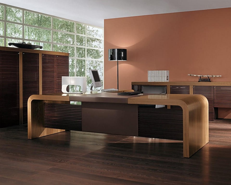 Tau is a large high - end executive desk in Italian walnut wood and a leather inlaid top and modesty panel. shown here with matching credenza and tall storage cupboards with doors in the glass and wiood strips design