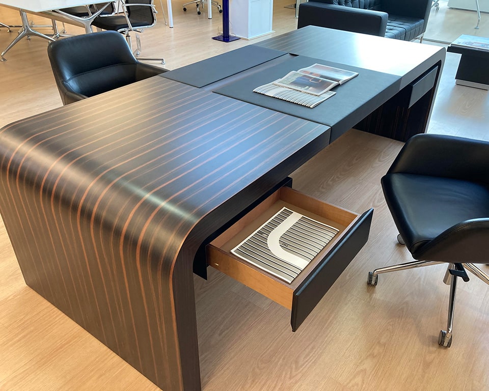 Tau is a high - end Chief executive directors desk in ebony wood with drawers and leather inlaid top. Shown with the small personal drawers instead of mobile drawers.