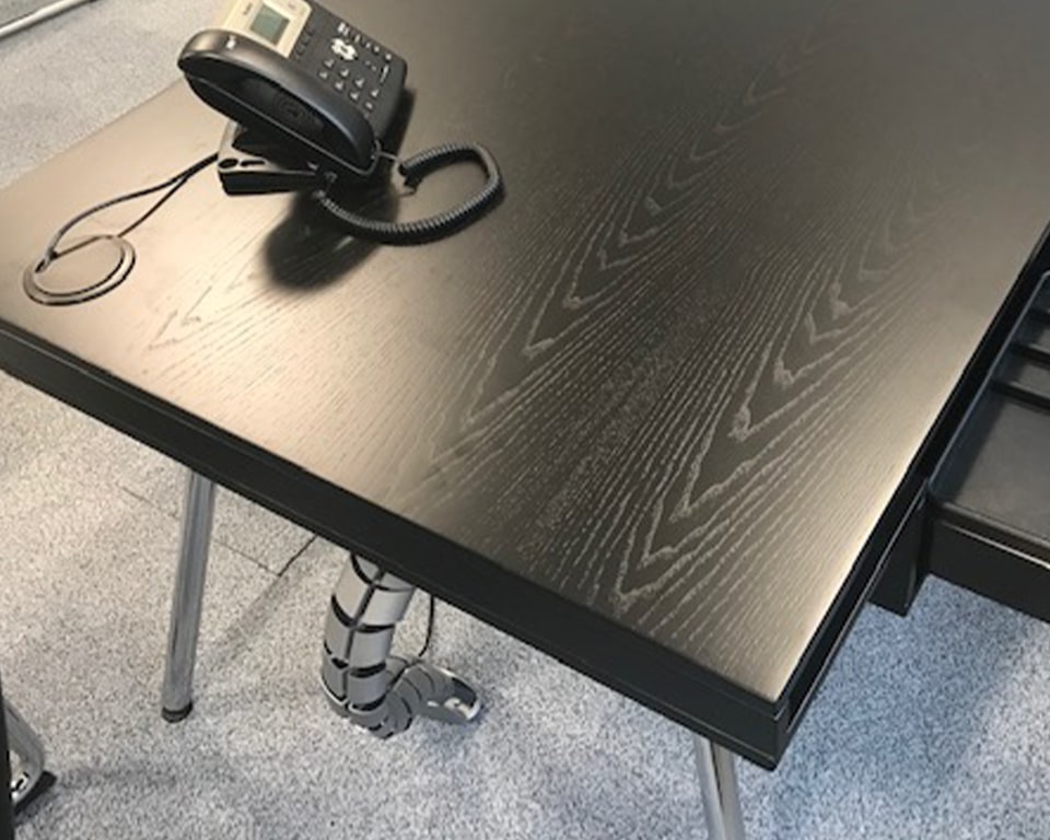 Premium Quality Black Executive Desk . Detail of the Black ash wood grain with chrome legs. Excellent wire management is afforded by the hollow desk top and a cable spine with cable holes on the desk top.