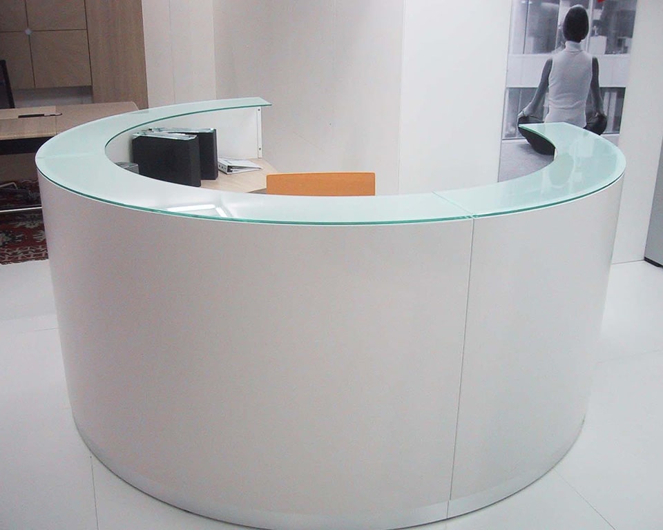 White Reception desk with a circular foot print made up of three modular semi circular components.