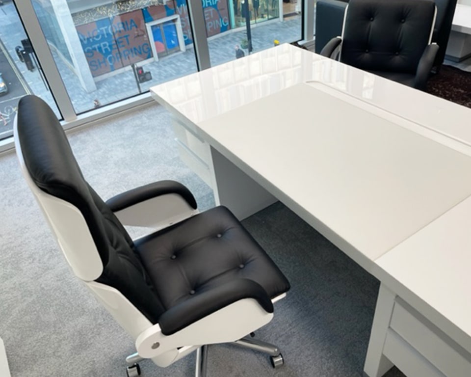 High back executive chair in white gloss and black leather with buttoned upholstery - behind a white gloss executive desk