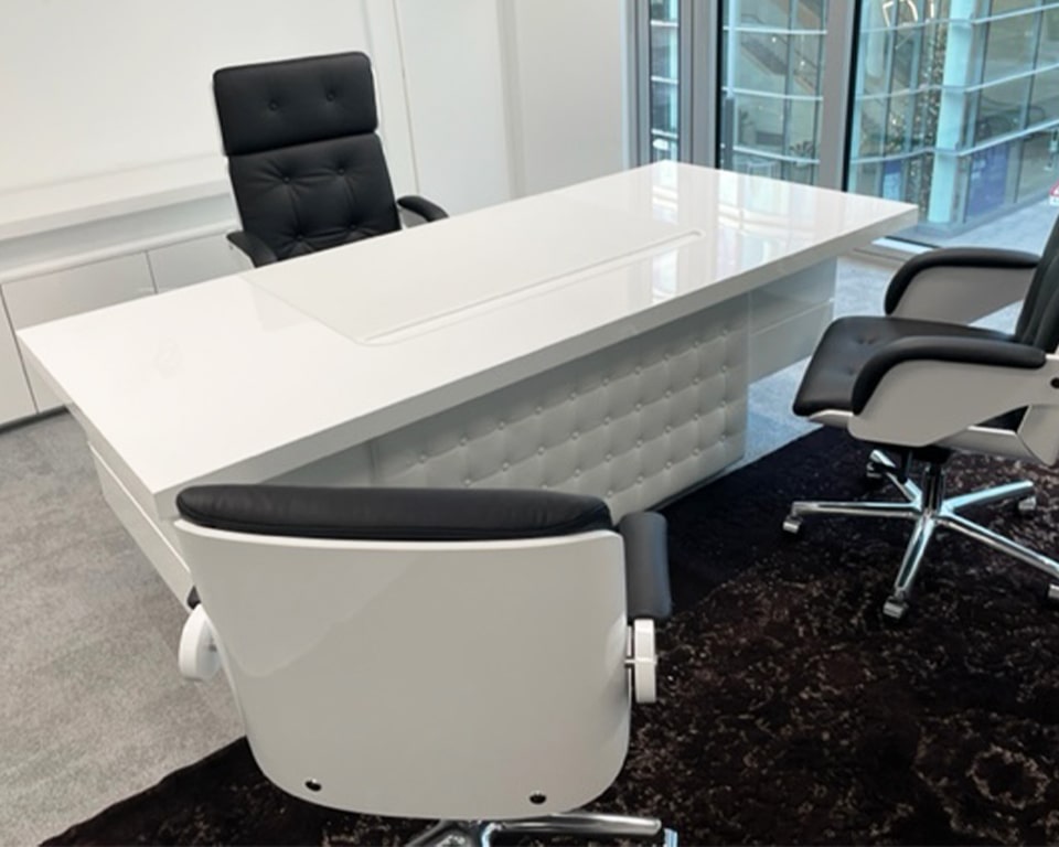 High white gloss executive desk with a white leather buttoned modesty panel shown with matching white gloss executive chairs - Taiko and Nesi ranges