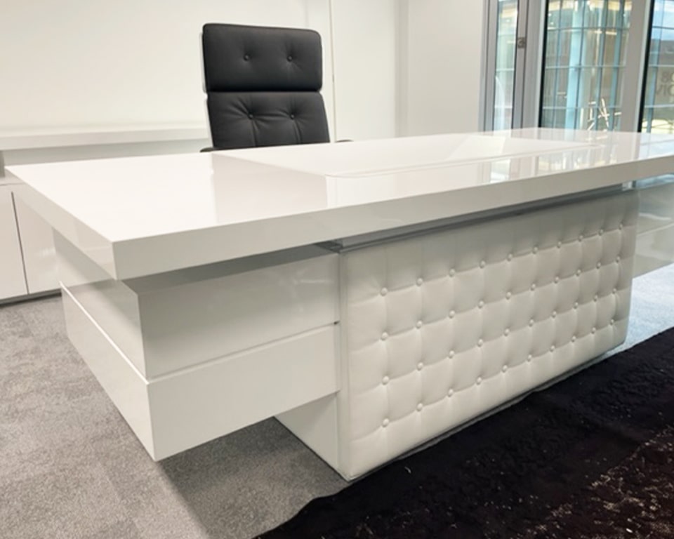 High white gloss executive desk with a white leather buttoned modesty panel shown with matching white gloss executive chair - Taiko and Nesi ranges