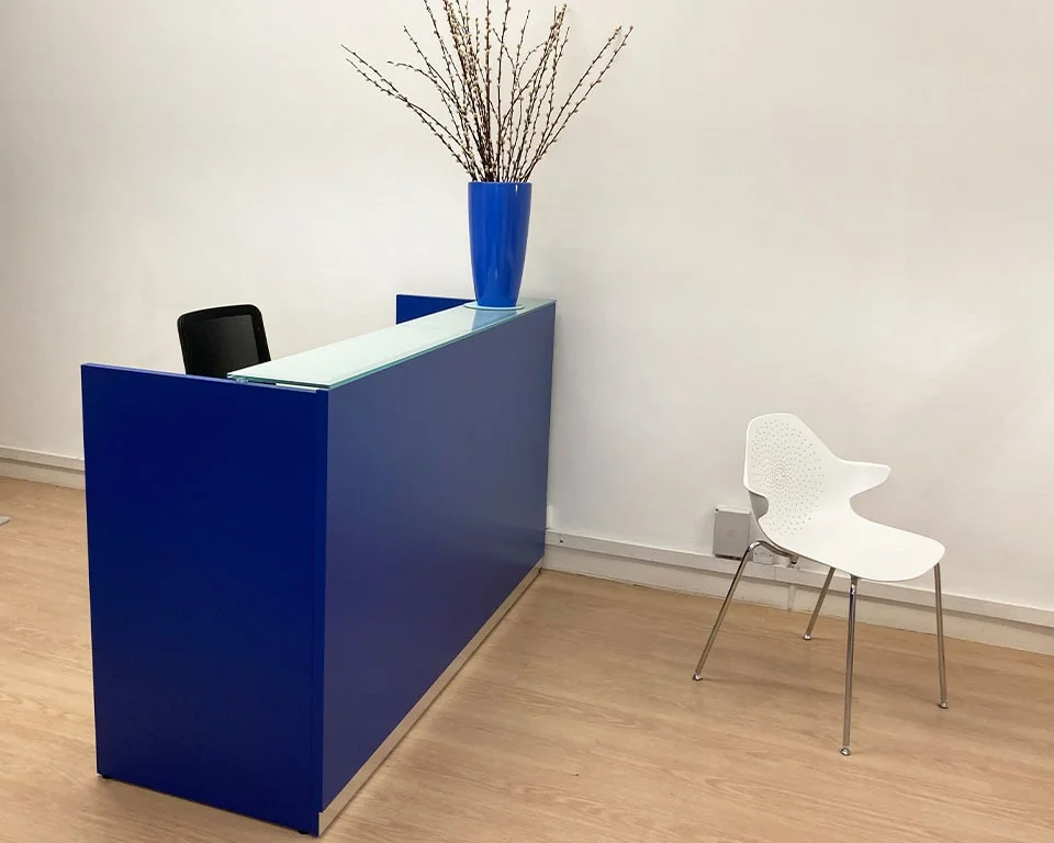 a stylish reception desk in dark blue with a glass counter top