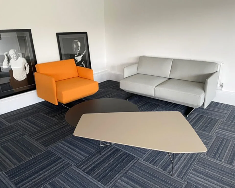 white leather two seat sofa with an arm chair in orange fabric