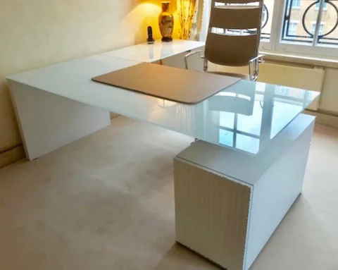 L-shaped white glass desk with non standard shiny glass tops
