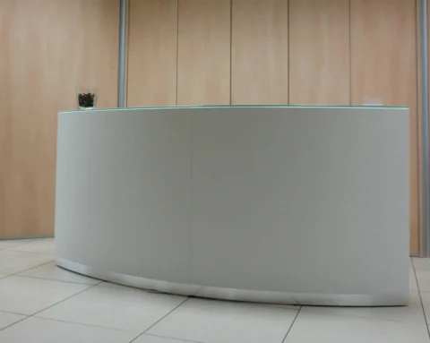 White semi circular reception desk with glass counter top